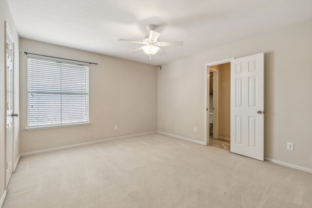 spare room featuring light carpet and ceiling fan