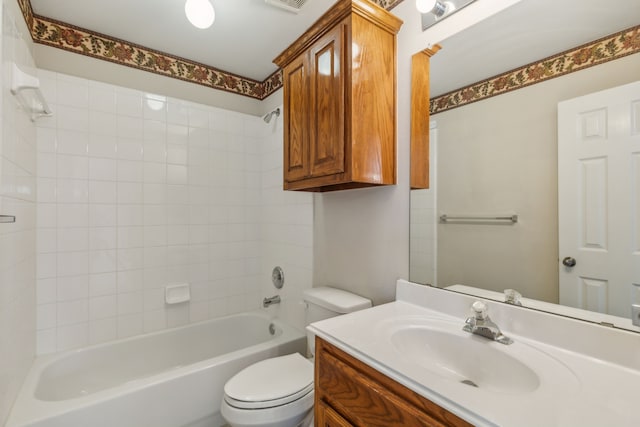 full bathroom featuring vanity, tiled shower / bath combo, and toilet