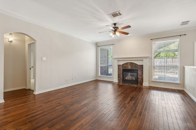 unfurnished living room with crown molding, ceiling fan, dark hardwood / wood-style flooring, and a fireplace