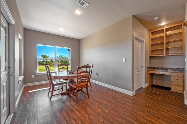 dining space featuring dark wood-type flooring and built in desk