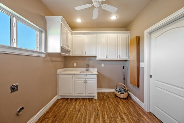 laundry room with hardwood / wood-style flooring, cabinets, hookup for an electric dryer, and sink