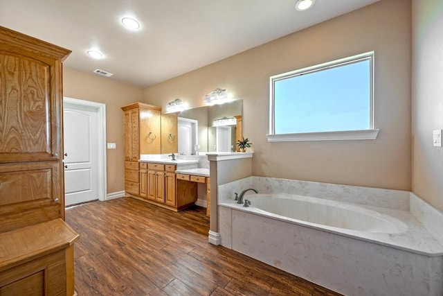 bathroom with vanity, hardwood / wood-style floors, and a tub