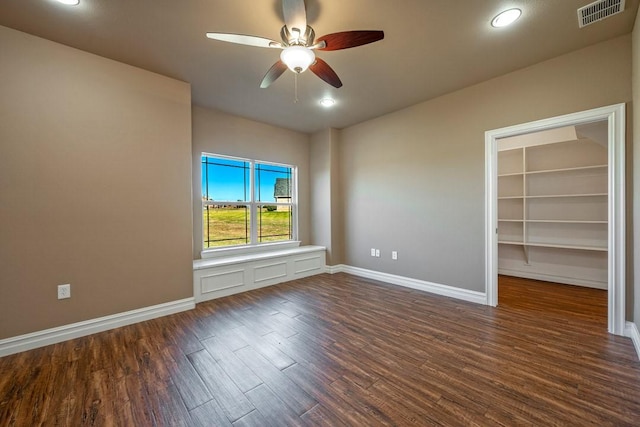 spare room with ceiling fan and dark wood-type flooring