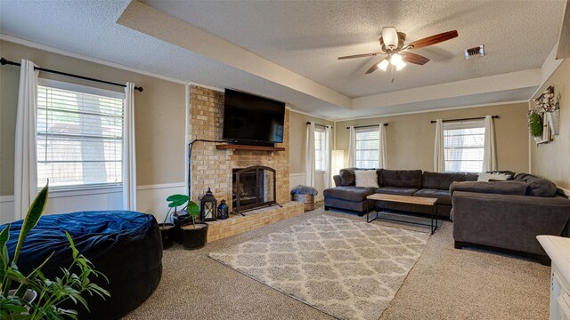 living room with a fireplace, a healthy amount of sunlight, and a textured ceiling