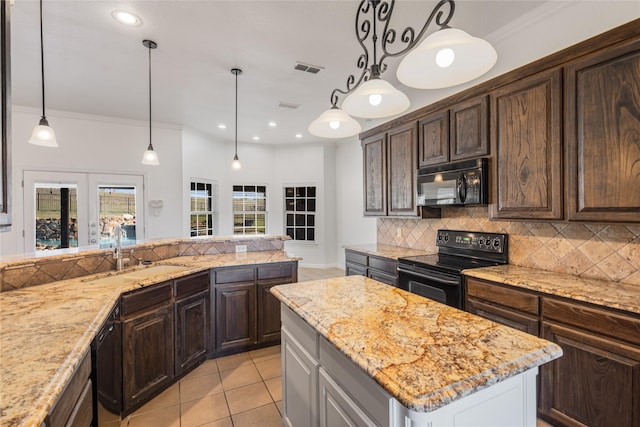 kitchen featuring a kitchen island, pendant lighting, tasteful backsplash, sink, and black appliances