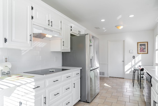 kitchen with white cabinets, decorative backsplash, stainless steel refrigerator with ice dispenser, and black electric cooktop