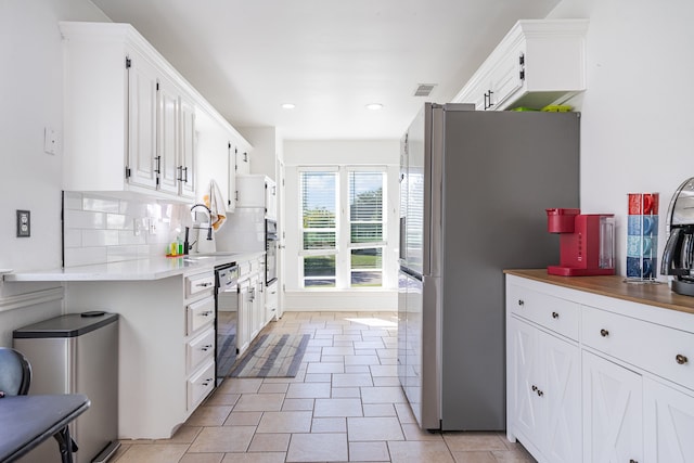 kitchen with decorative backsplash, white cabinetry, sink, and appliances with stainless steel finishes