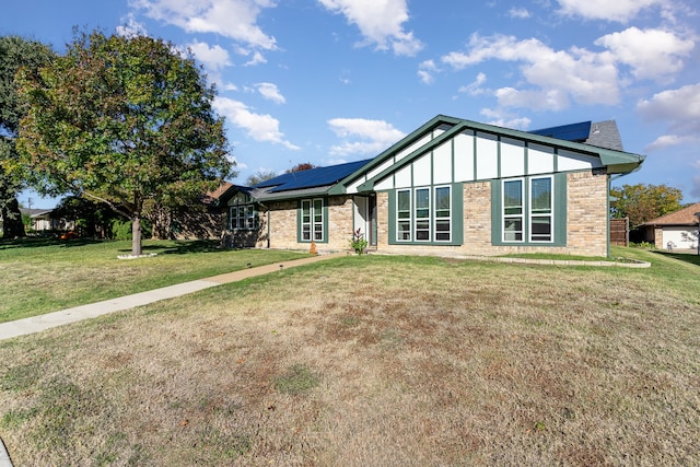 view of front of house with a front yard and solar panels