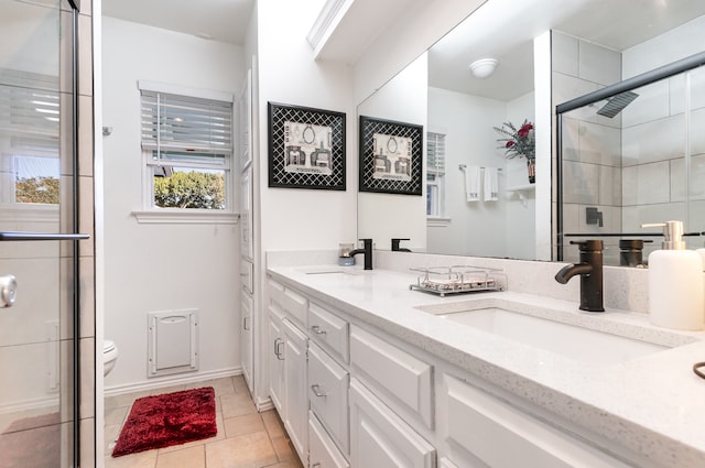 bathroom with tile patterned floors, plenty of natural light, vanity, and toilet