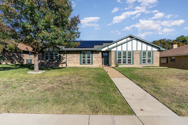 view of front of house with a front lawn and solar panels