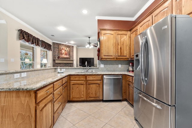 kitchen with appliances with stainless steel finishes, tasteful backsplash, light tile patterned floors, crown molding, and light stone countertops