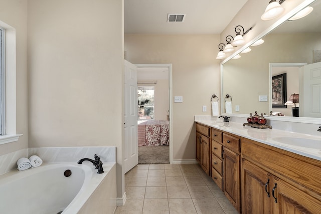 bathroom featuring vanity, tile patterned flooring, and a tub