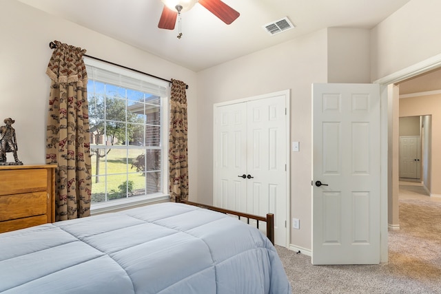 carpeted bedroom with multiple windows, ceiling fan, and a closet