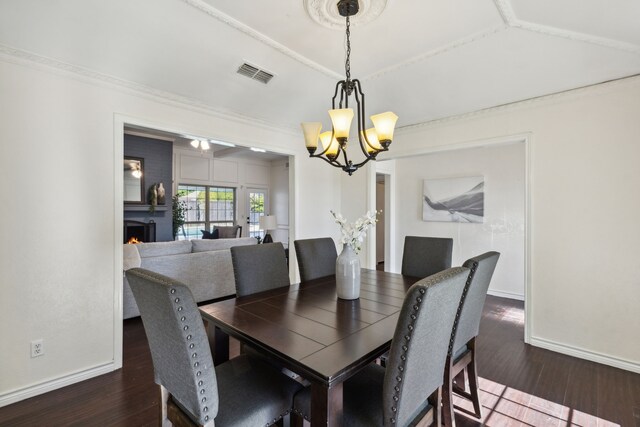 dining room with a notable chandelier, crown molding, and dark hardwood / wood-style flooring