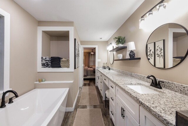 bathroom with vanity, a bathing tub, and hardwood / wood-style flooring