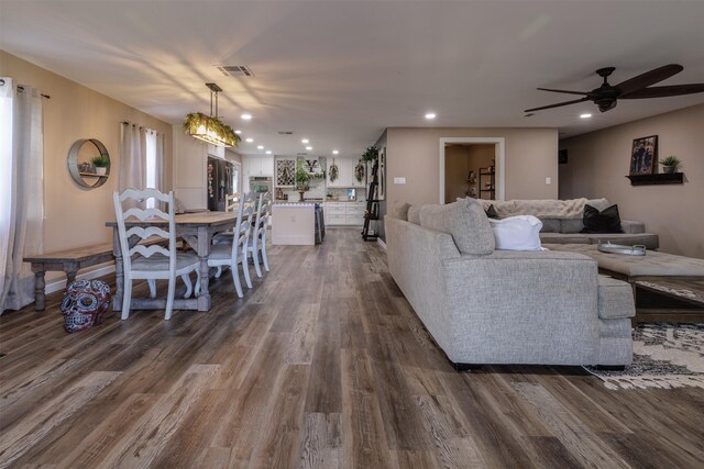 living room featuring ceiling fan and dark hardwood / wood-style flooring