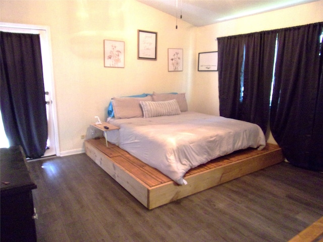 bedroom with dark hardwood / wood-style floors and lofted ceiling