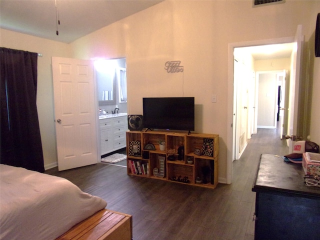 bedroom with vaulted ceiling, ensuite bath, and dark hardwood / wood-style floors