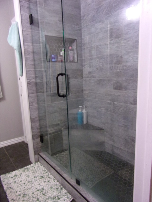 bathroom featuring tile patterned floors and a shower with shower door