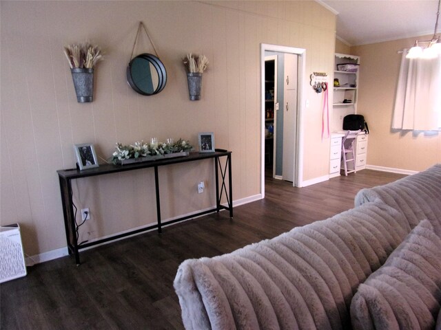 living room with dark hardwood / wood-style flooring, ornamental molding, and vaulted ceiling