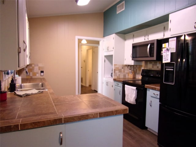 kitchen featuring black appliances, sink, dark hardwood / wood-style floors, tasteful backsplash, and white cabinetry