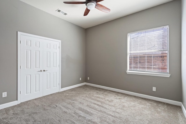 carpeted spare room featuring ceiling fan