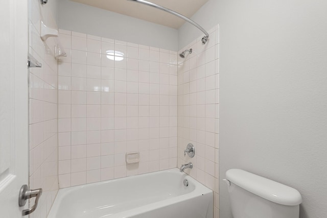 bathroom featuring tiled shower / bath combo and toilet