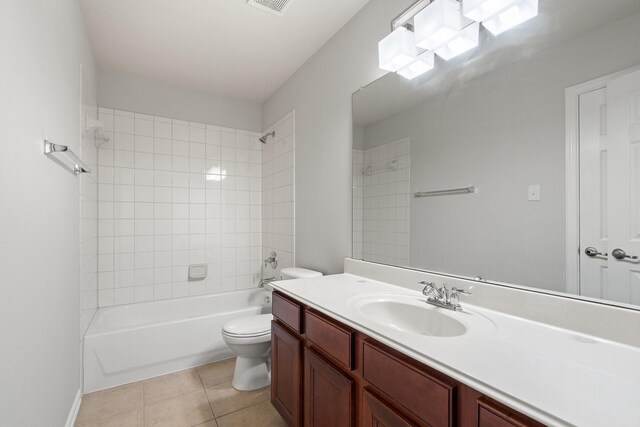 full bathroom featuring tile patterned flooring, vanity, toilet, and tiled shower / bath