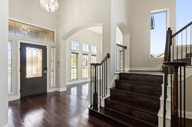 entryway featuring a notable chandelier, dark hardwood / wood-style floors, and a high ceiling