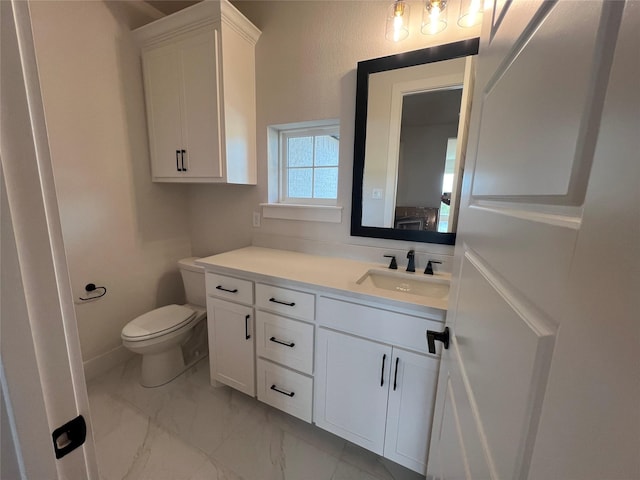 bathroom with toilet, marble finish floor, baseboards, and vanity