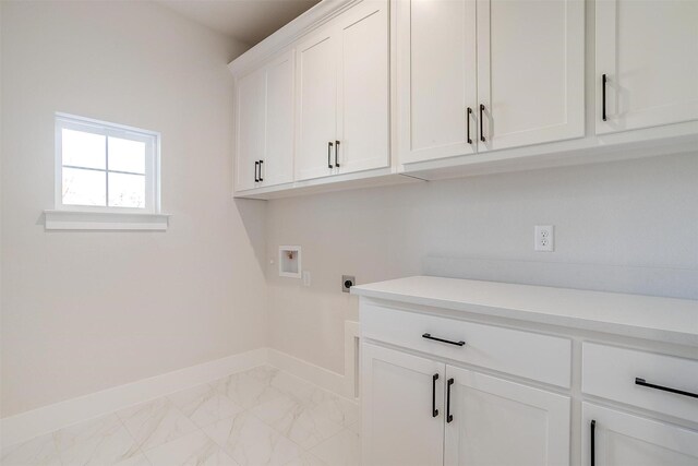 clothes washing area with hookup for an electric dryer, hookup for a washing machine, cabinets, and sink