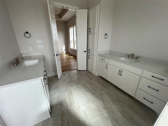 bathroom with marble finish floor, baseboards, and vanity