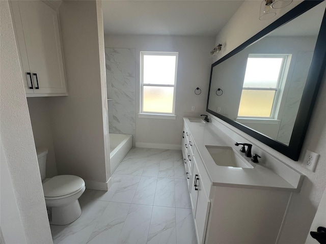 bathroom featuring toilet, marble finish floor, baseboards, and a sink