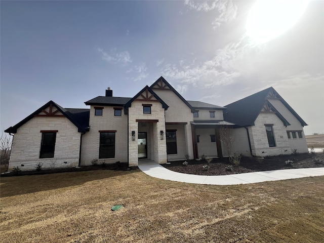 view of front of home featuring a front lawn and a chimney