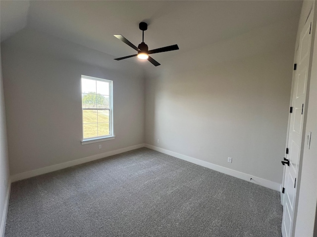 empty room featuring carpet floors, lofted ceiling, ceiling fan, and baseboards