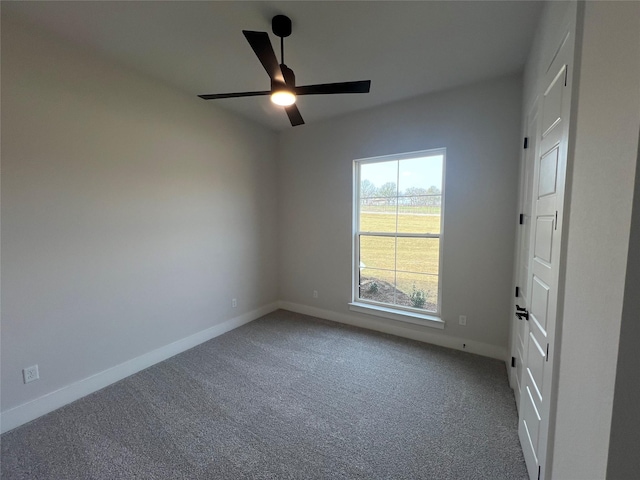 carpeted empty room featuring a ceiling fan and baseboards