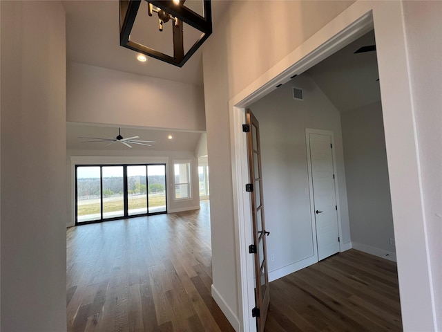 hallway with recessed lighting, visible vents, baseboards, and wood finished floors