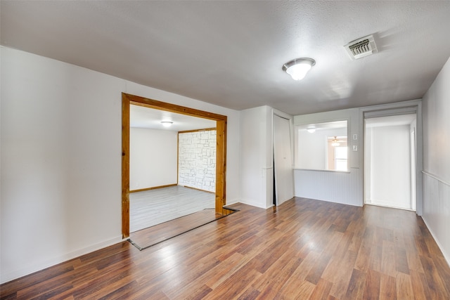 empty room featuring a textured ceiling and dark wood-type flooring