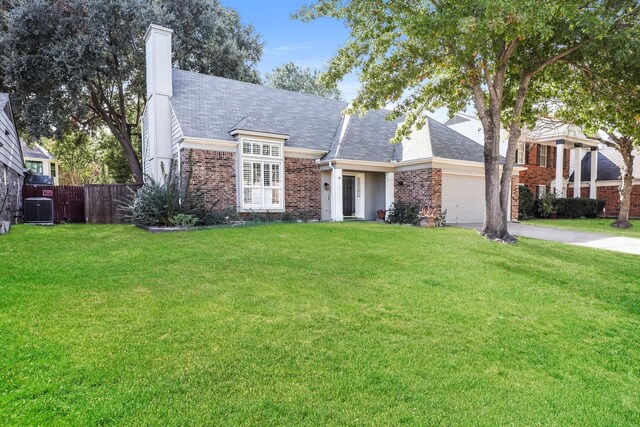 view of front of house featuring cooling unit, a garage, and a front lawn