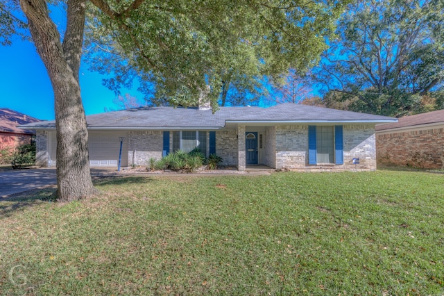 ranch-style house featuring a garage and a front yard