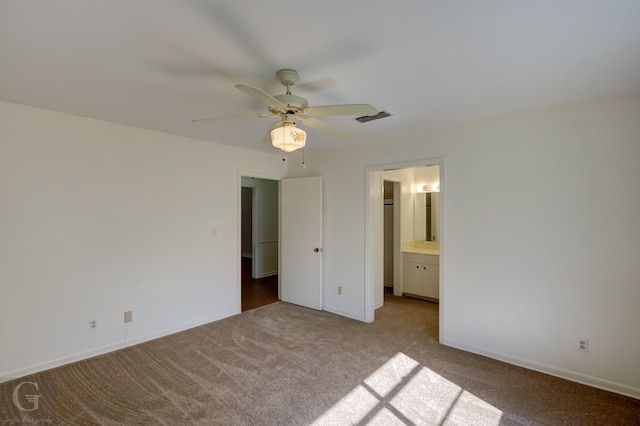 unfurnished bedroom with ceiling fan, light colored carpet, and ensuite bathroom