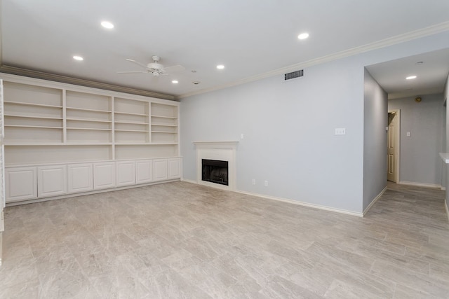 unfurnished living room with built in shelves, ceiling fan, and crown molding