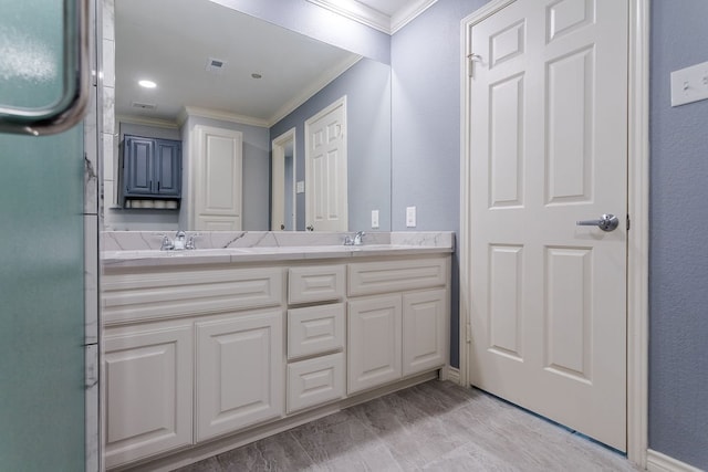 bathroom featuring wood-type flooring, vanity, and crown molding