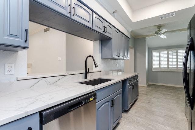 kitchen with dishwasher, black fridge, sink, ceiling fan, and light stone countertops