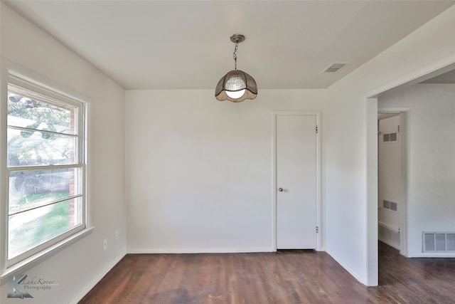 unfurnished room featuring plenty of natural light and dark wood-type flooring