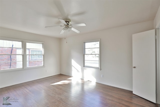 unfurnished room with dark wood-type flooring, ceiling fan, and a healthy amount of sunlight