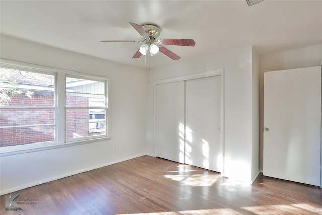 unfurnished bedroom with ceiling fan, light hardwood / wood-style floors, and a closet