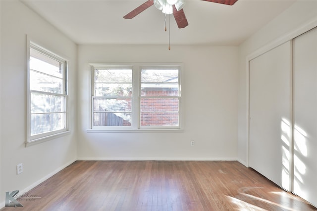 spare room with light hardwood / wood-style floors, ceiling fan, and a healthy amount of sunlight