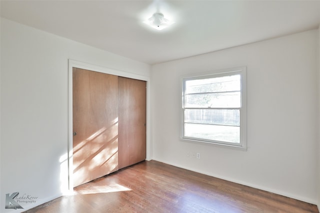 unfurnished bedroom featuring wood-type flooring and a closet