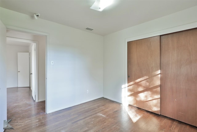 unfurnished bedroom with hardwood / wood-style floors and a closet